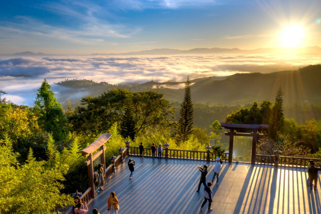 Capture the beauty of a sunrise over a misty valley with a shrine and observation platform in the foreground.